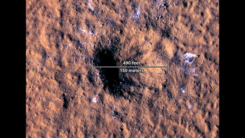 The impact crater, formed Dec. 24, 2021, by a meteoroid strike in the Amazonis Planitia region of Mars, is about 490 feet (150 meters) across, as seen in this annotated image taken by the High-Resolution Imaging Science Experiment (HiRISE camera) aboard NASA's Reconnaissance Orbiter.